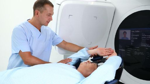 Radiotherapist supporting a patient in an Elekta Harmony