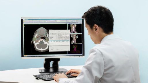 Doctor reviewing treatment plan screen on monitor
