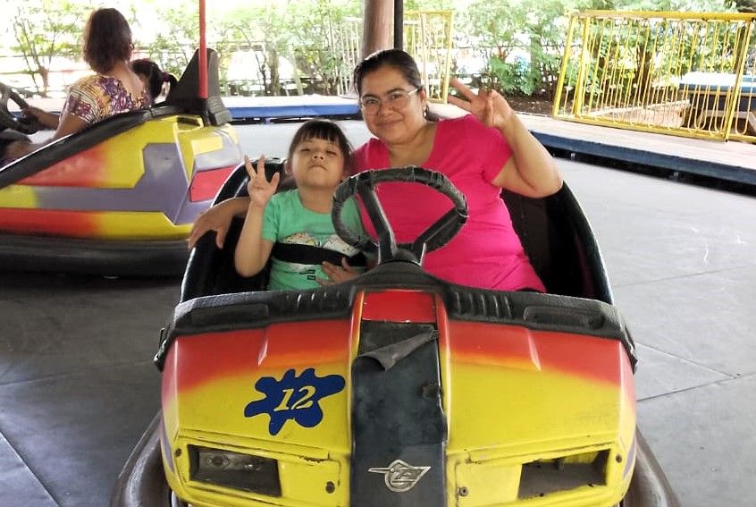 Abby Villagrán riding a bumper car with her mother