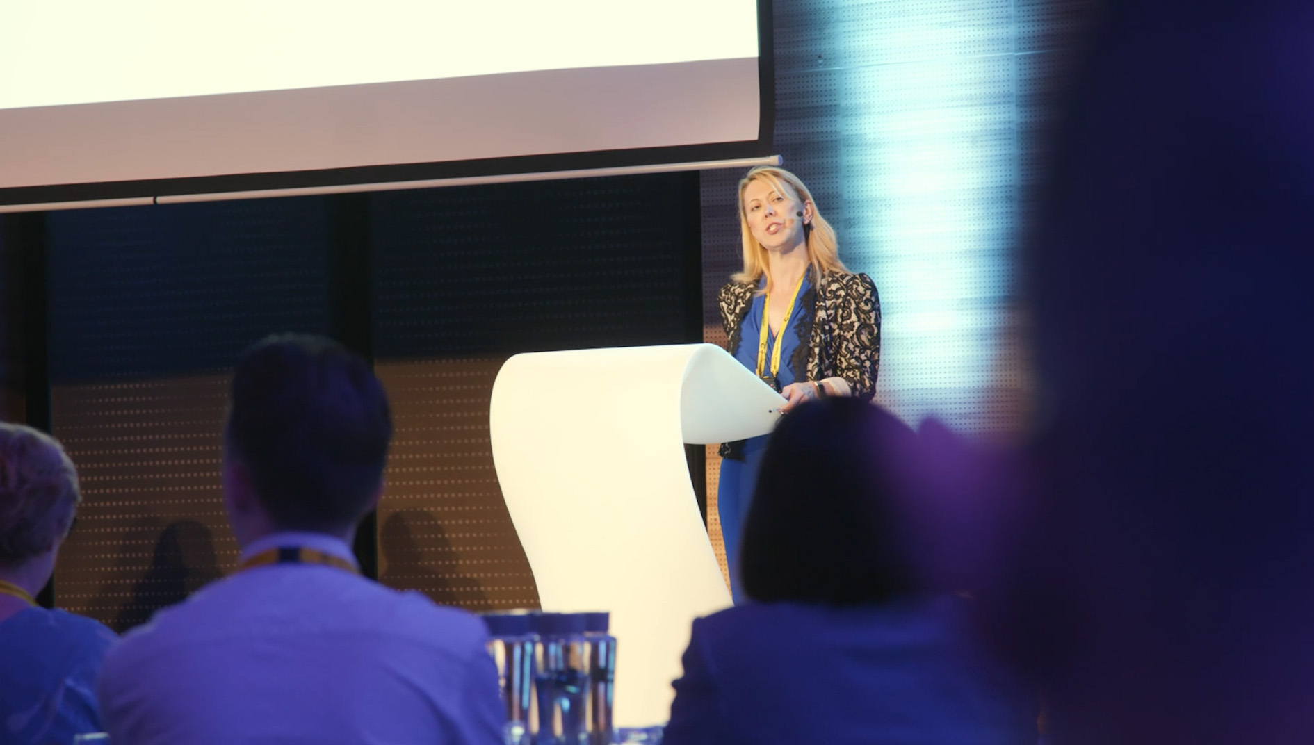 Alison Tree holding a speech on stage during a MR Linac Consortium event