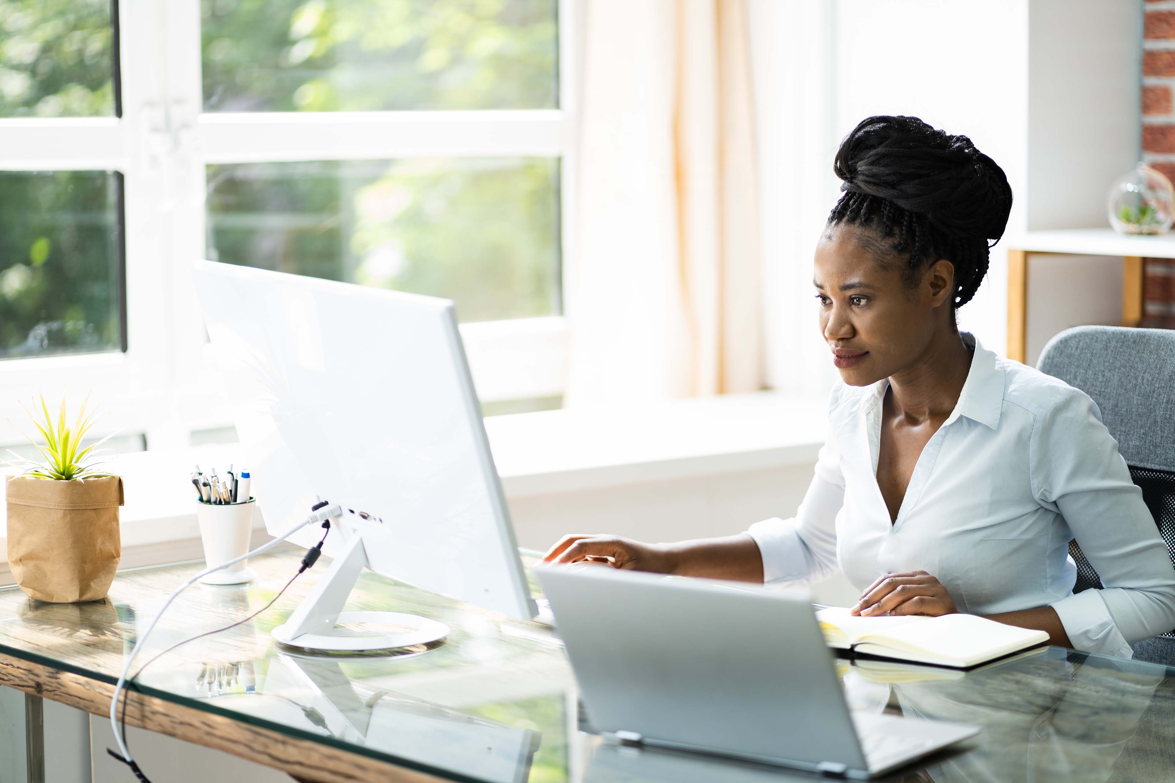 Woman at computer desk looking at training documentation