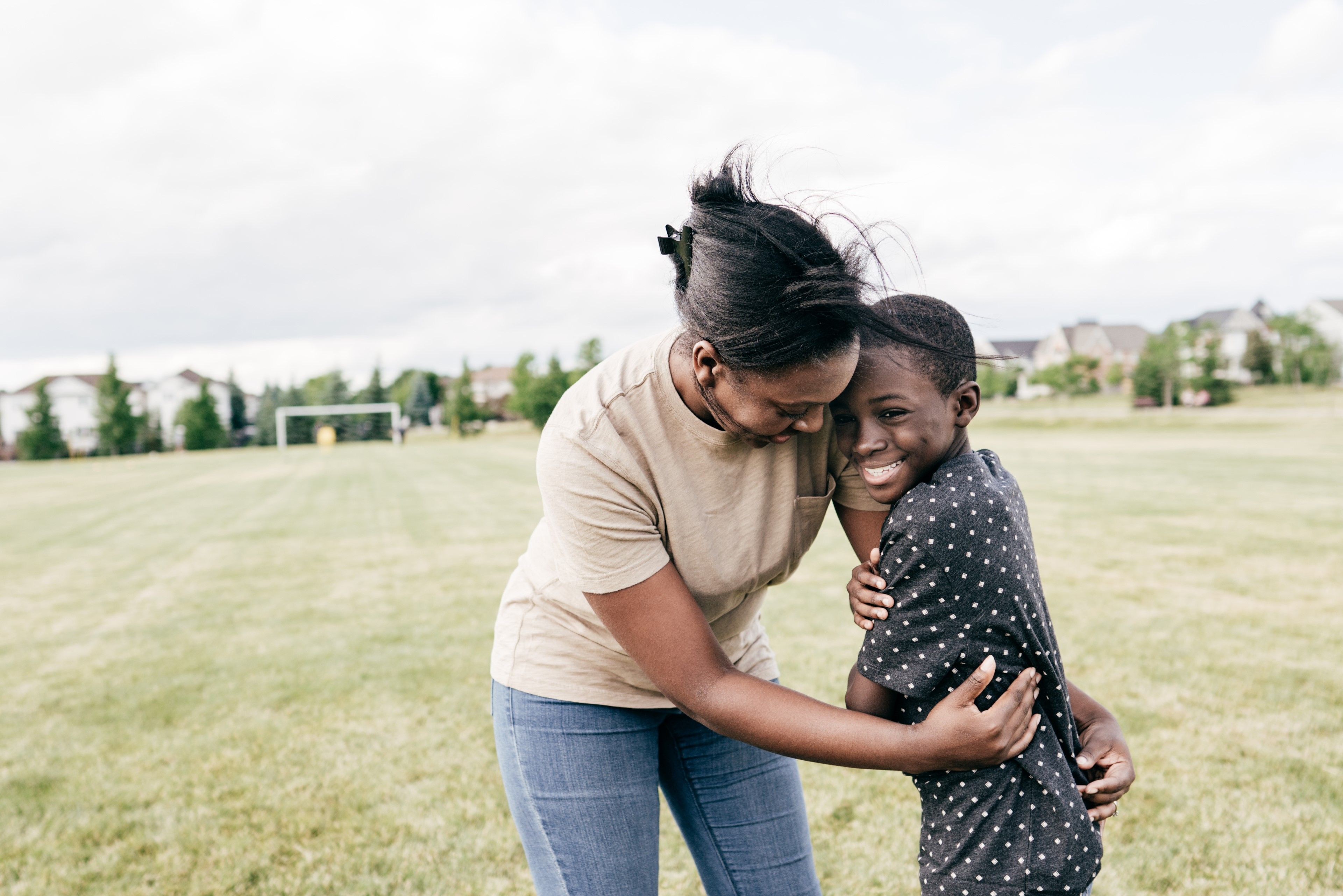 Mother and son hugging on a football pitch
