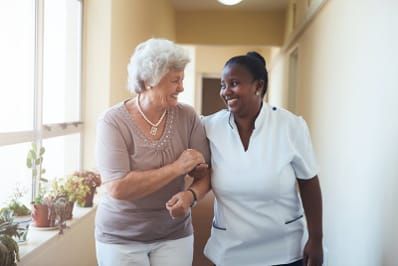 Elderly lady with a nurse walking down the corridor of a hospital