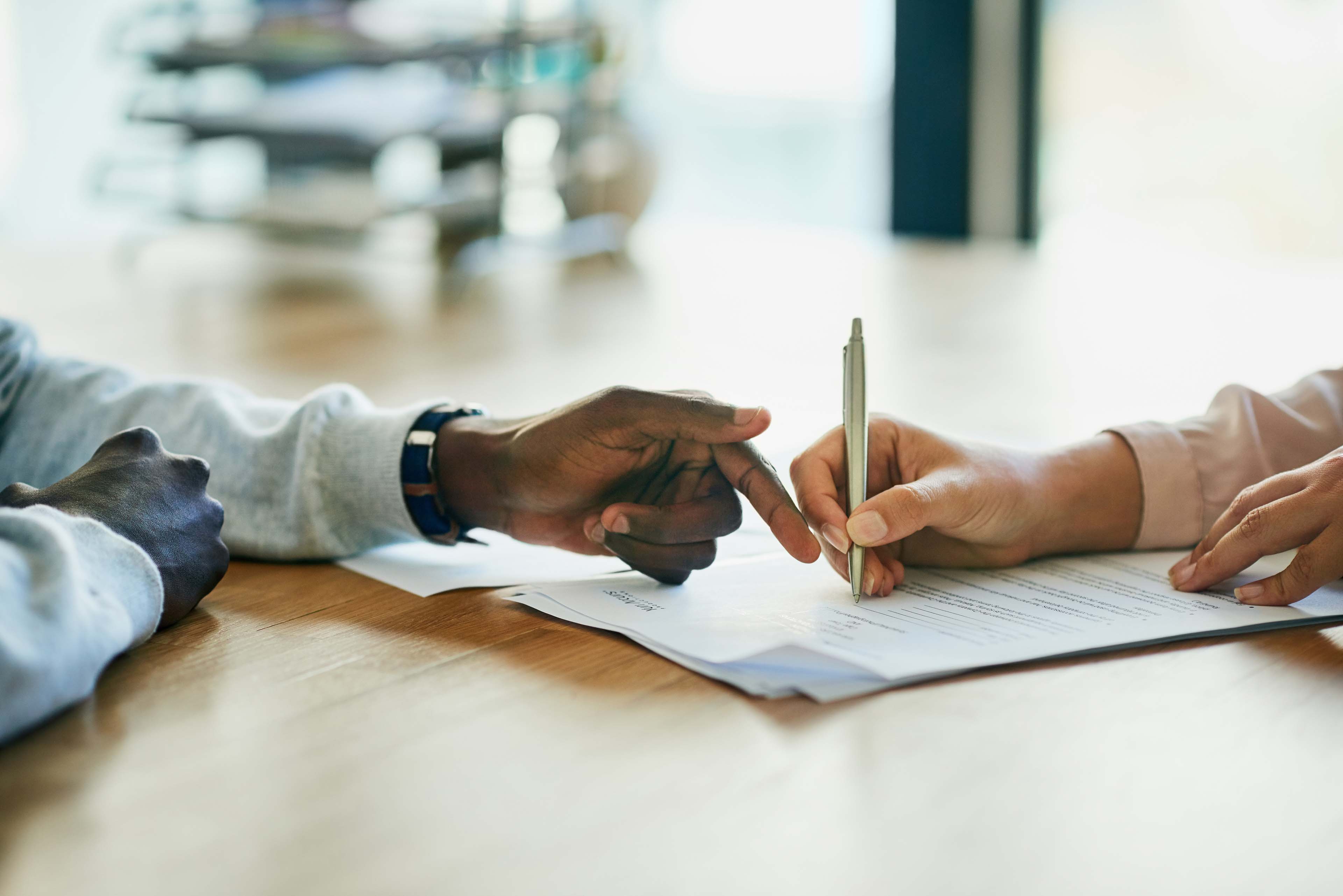 Two people signing terms and conditions documents